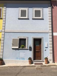 uma casa azul com duas janelas e uma porta em Casa Azzurra em Santa Teresa Gallura