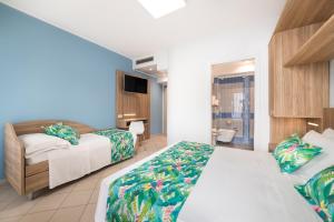 a hotel room with two beds and a television at Amalfi smart Rooms & Apartments - Ideale per Ragazzi in Riccione