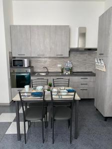 a kitchen with a table and chairs in a kitchen at APPARTAMENTI TRA CIELO E MARE in Piombino