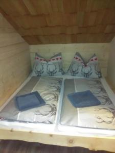 Una cama con cuatro almohadas encima. en Troadkasten Seinerzeit, en Aich