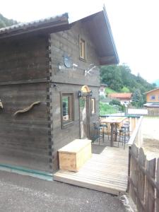 a wooden cabin with a table on a deck at Troadkasten Seinerzeit in Aich