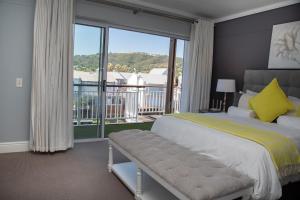 1 dormitorio con cama y ventana grande en WATERFRONT NEW LISTNG - 8 SOUTH QUAY -, en Knysna