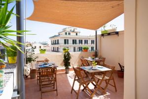 patio ze stołami i krzesłami na balkonie w obiekcie Quattro Incanti w mieście Palermo