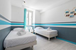 ニースにあるAmazing 3 Bdrs and Garden Place du Pin Parking !の青と白のストライプを用いた客室のベッド2台