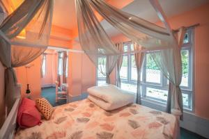 a bedroom with a canopy bed and a window at Tag Along 2 0 Hostel Gangtok in Gangtok