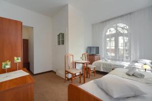 1 dormitorio con 2 camas, mesa y sillas en Stella, en Krynica-Zdrój