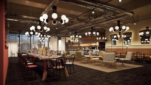 a restaurant with a long table and chairs and lights at AMERON München Motorworld in Munich