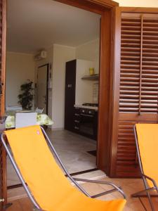 una silla amarilla en una habitación con cocina en Virgilio Apartment, en Trapani