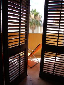 una puerta que conduce a una habitación con una palmera en Virgilio Apartment, en Trapani