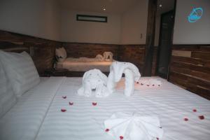 a bed with two white elephants and roses on it at Amacon Hotel & Coffee in Buôn Kô Sir