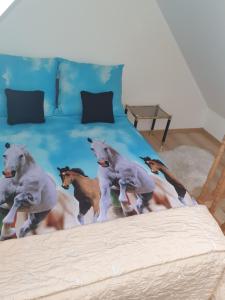a bed with a painting of horses on it at Apartament Limonka in Wierzchucino