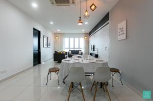 uma sala de jantar com mesa e cadeiras em Jomstay Octagon Duplex Penthouse Ipoh Town em Ipoh