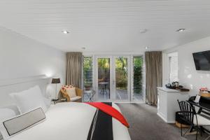 a bedroom with a bed and a desk with a television at Acacia Cliffs Lodge in Taupo