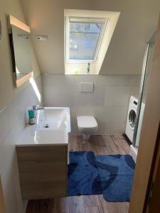 uma casa de banho com um lavatório, um WC e uma janela. em Ferienwohnung Braeuer em Chemnitz