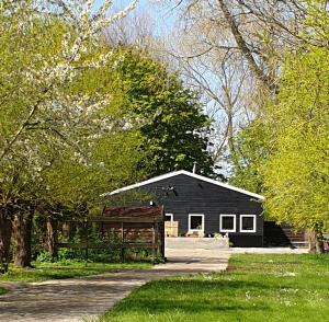 a black house with a fence in front of it at Vakantiewoning "In Between" in Oostkapelle