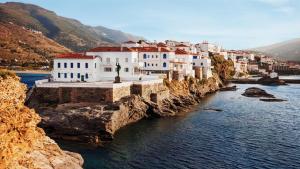 a group of white buildings on the side of a river at Castel Abaso Boutique Apartments by Explore Andros in Andros
