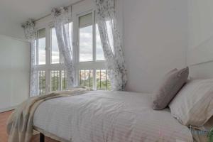 ein Schlafzimmer mit einem Bett und einem großen Fenster in der Unterkunft Tres dormitorios vistas al mar junto a la playa in Punta Umbría