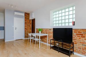 a living room with a brick wall and a tv at Apartament w centrum, zarezerwuj teraz in Lublin