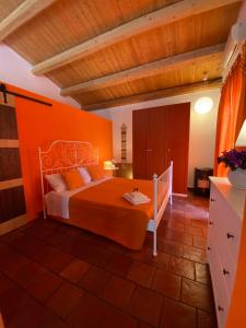 a bedroom with a bed with an orange wall at Orecchie di Lepre in Siracusa