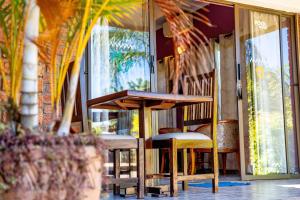 a table and chairs in front of a window at Dzimbahwe Guest Lodge in Victoria Falls