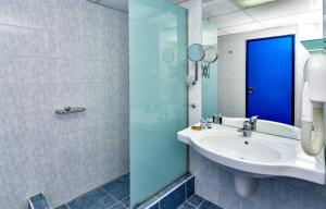 a bathroom with a sink and a blue door at Hotel Mura in Albena