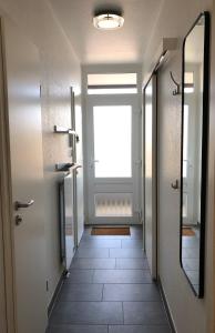a hallway with a door with a window and a mirror at Vier Jahreszeiten 6-12 in Großenbrode