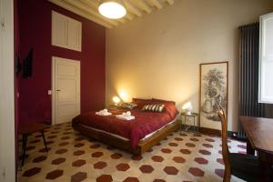 a bedroom with a bed in a red wall at La Terrazza Del Fotografo in Lucca