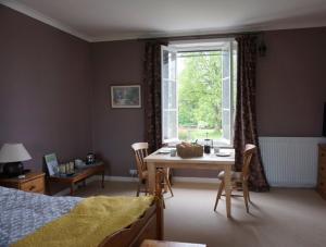 um quarto com uma cama, uma mesa e uma janela em Le Tulipier de la Serre em Saint-Yrieix-la-Perche