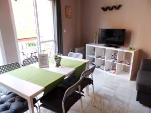uma sala de estar com uma mesa e uma televisão em ENJOY Apart. Centro y Playa Cervantes em Málaga