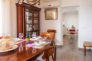 un comedor con una mesa de madera con platos y copas de vino en Villa Aucanada, en Alcudia
