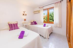 アルクーディアにあるVilla Aucanadaの白い部屋のベッド2台 紫色の枕付