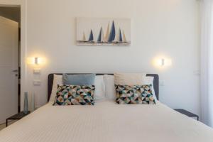 a bedroom with a white bed with two pillows at Residence Meridian Unità 7 in Villa San Pietro
