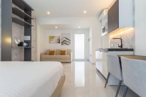 a white bedroom with a bed and a kitchen at Residence Meridian Unità 6 in Villa San Pietro