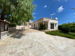 a patio in front of a white house at Il Pepe Rosa - Valle D'Itria in Martina Franca