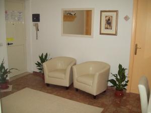 una sala de espera con 2 sillas y un espejo en B&B RoGe, en Olbia