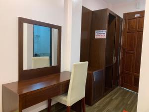 a desk with a mirror and a chair in a room at Hotel Ngoc Anh - Van Don in Quang Ninh +24 photos