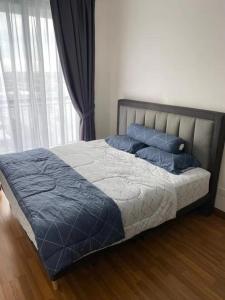 a bed with blue pillows in a bedroom with a window at YANGTZE HOME STAY 长江民宿 in Johor Bahru