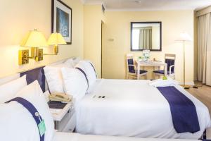 a hotel room with two beds and a table at Holiday Inn Lisbon by IHG in Lisbon