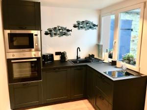 a kitchen with a sink and a microwave at Cherbourg Sea Sand in Cherbourg en Cotentin