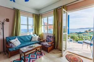 a living room with a couch and a view of the ocean at Koroni Seaview Retreats - Summer Escape Lodgings in Koroni