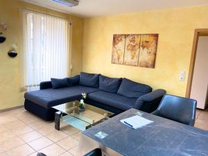 a living room with a blue couch and a table at Apartments Rhona I und II Neunkirchen City in Neunkirchen