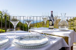 Deville & Spa في كوسترمانو: طاولة مع كؤوس وصحون وزجاجة من النبيذ
