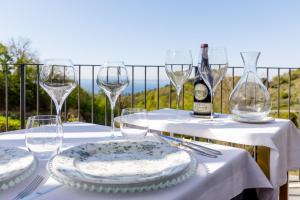 una mesa con copas y platos y una botella de vino en Deville & Spa en Costermano