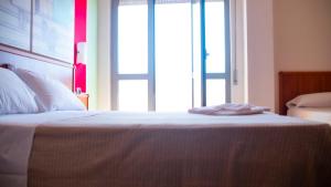 a bedroom with a bed with a large window at Hotel Royal in Giulianova