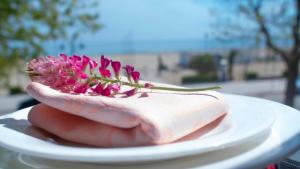 a piece of food on a plate with a flower on it at Hotel Royal in Giulianova