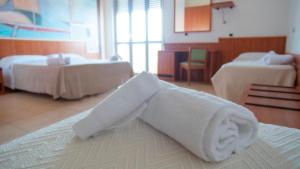 a towel laying on a bed in a hotel room at Hotel Royal in Giulianova