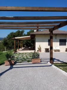 pérgola de madera frente a un edificio en Podere Battegone, en Menestrello