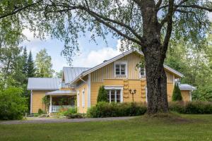 a yellow house with a tree in front of it at Taulun Kartano in Kankainen