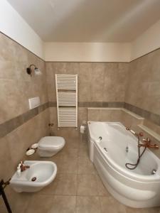 a bathroom with a tub and a toilet and a sink at Il Pepe Rosa - Valle D'Itria in Martina Franca +6 photos