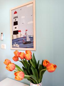 una foto di un faro e di un vaso con fiori d'arancio di Goccia Azzurra a Silvi Marina